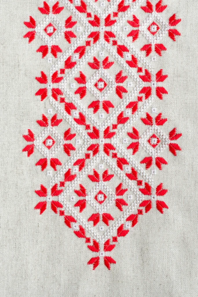 Geometric embroidery design using white and red cotton threads on flax