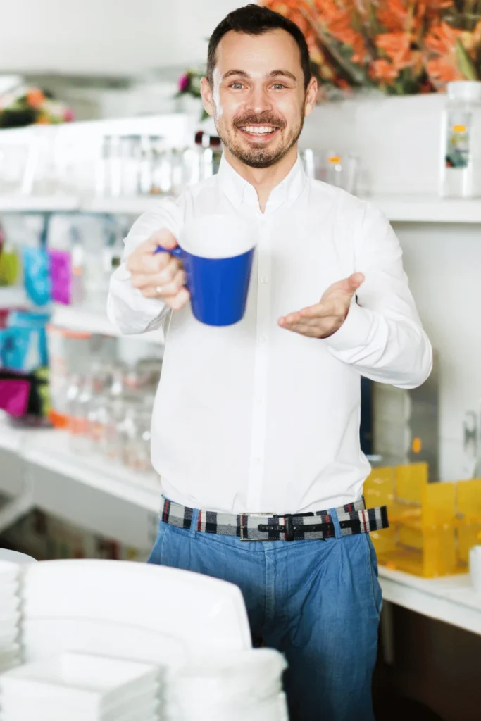image of a man showing the blue mug he made